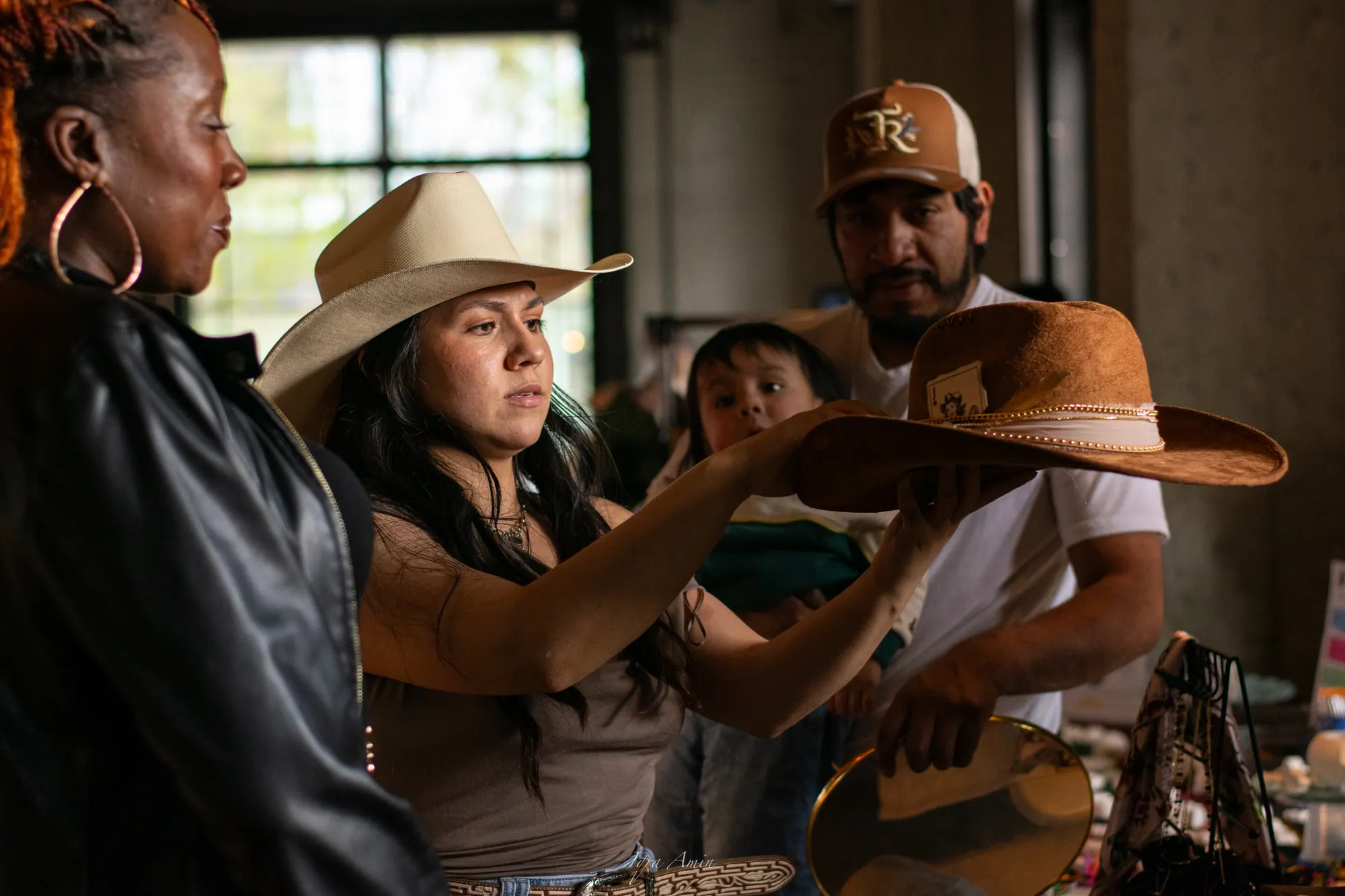 A musician adjusts a hat on a young woman before a performance