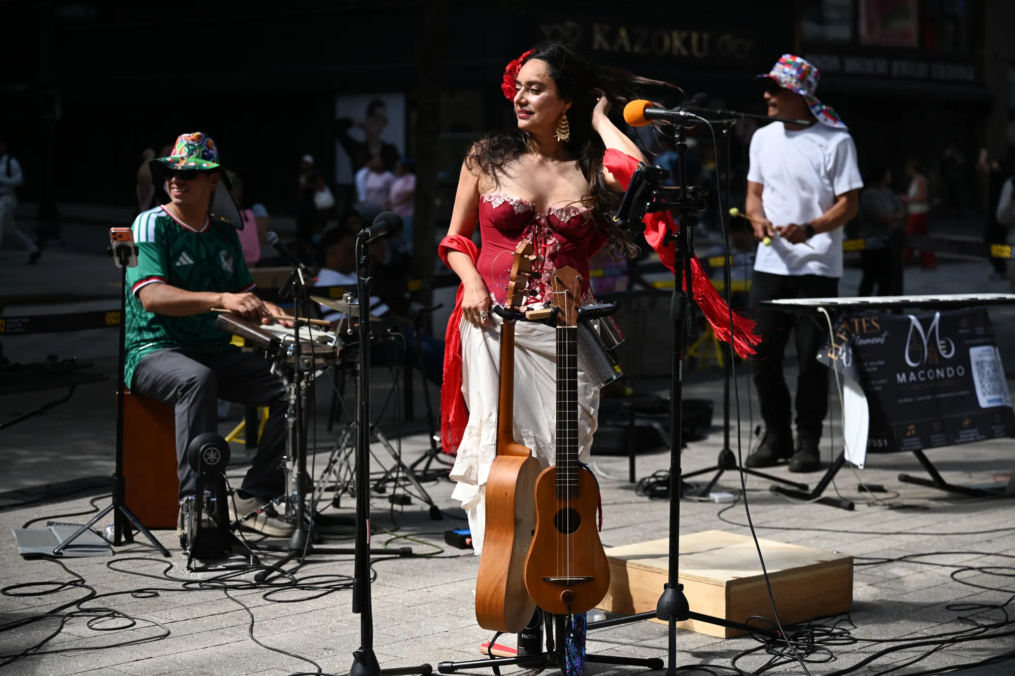 Zaira Meneses singing with her jarana on an outdoor stage